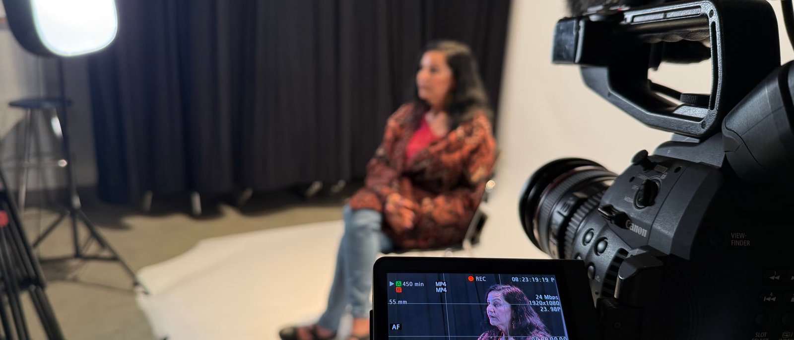 A student sitting for a lit interview setup in the Cabrillo studio, camera and monitor in frame